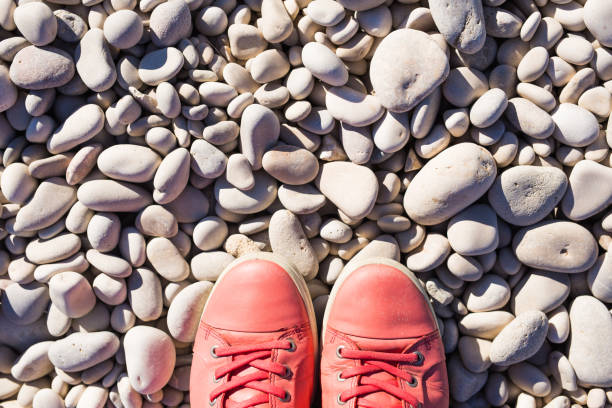 istock Red sneakers on pebbles, top view 1002325038