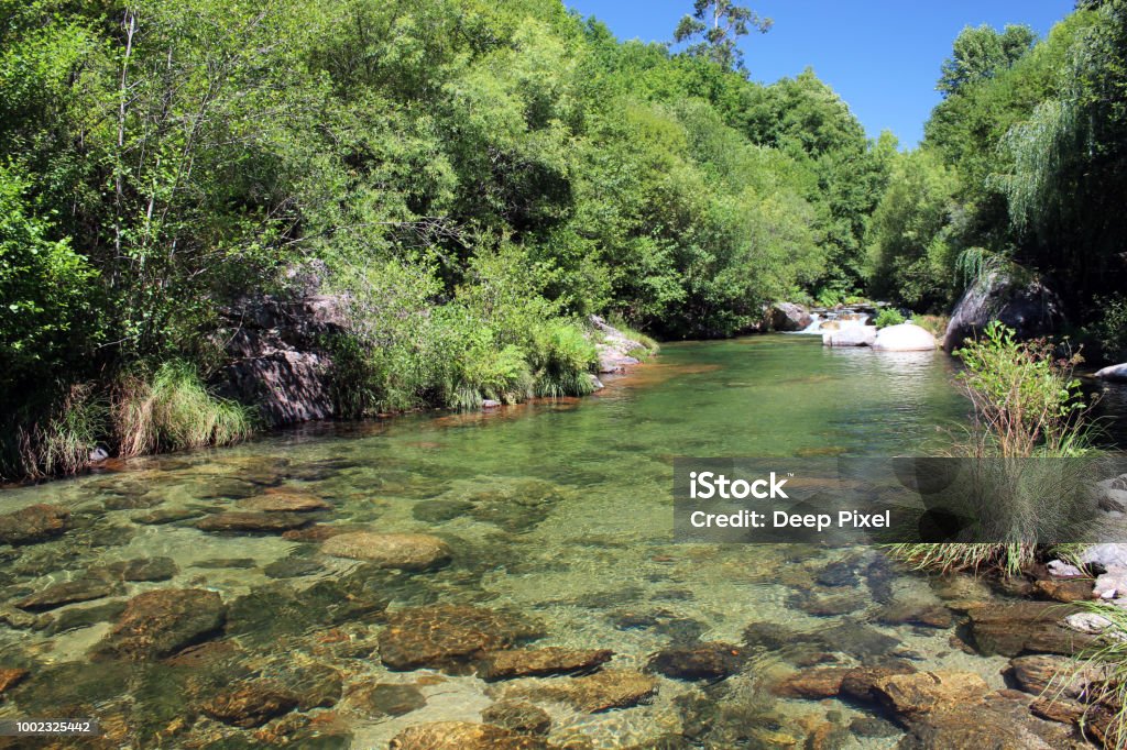 Clear water at Cavado River - 2 Water stream with a small waterfall. Clean, transparent, pristine water near a hydroelectric power station in Cavado River, Geres, Portugal Aerial View Stock Photo