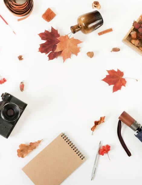 istock Autumn composition background. Artist home office desk workspace , autumn leaves, old camera, notebook, umbrella on  white background. Flat lay, top view creative minimal mock up template.  Copy space 1002329466