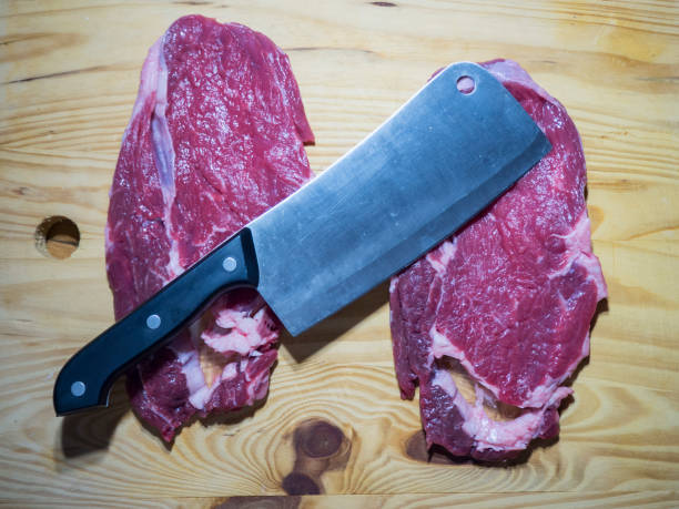istock beef steak on wooden floor and very sharp line knife over 1002333882