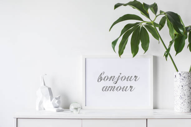 istock Stylish and modern white interior with mock up frame , cacti and cat figures. White concept of cupboard shelf. 1002339798