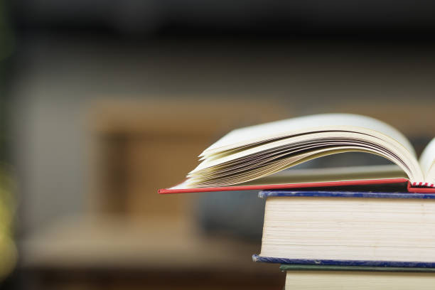 istock Close-up open vintage book on stack books background. Back to school concept with copy space. Books background for display your work. 1002342614