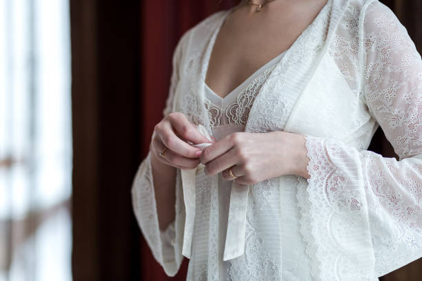 istock bride in a robe near the window,woman getting ready before wedding ceremony 1002344338