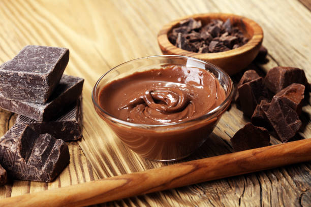 istock Melting chocolate  or melted chocolate with a chocolate swirl. Many stack and chips with powder. 1002372834