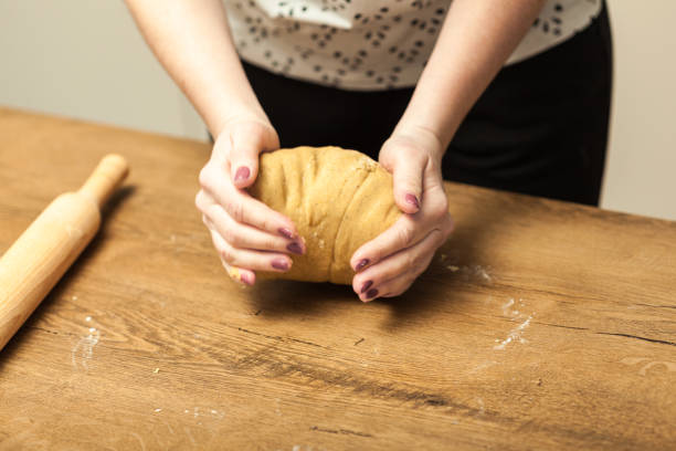 istock Hands rolling dough for gingerbread on the wooden table 1002372926