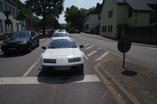 Trier, Germany, - July 14, 2018. Vintage sports car crossing the street on a warm summer day.