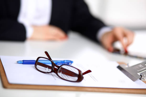 istock Young woman sitting  at the desk with folder 1002377040
