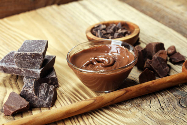 istock Melting chocolate  or melted chocolate with a chocolate swirl. Many stack and chips with powder. 1002377976