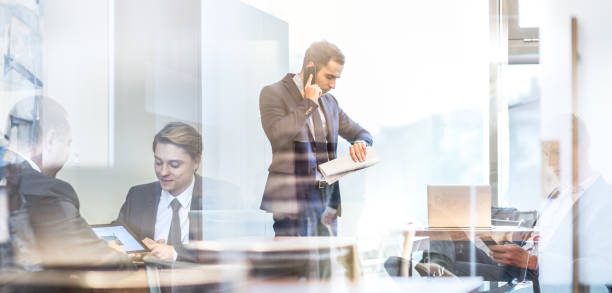 istock Businessman talking on a mobile phone on corporate office. 1002406820