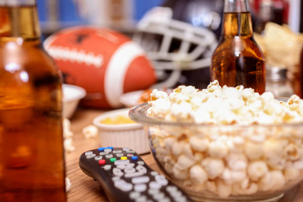 istock Watching the football game with snacks, drinks. 1002409496