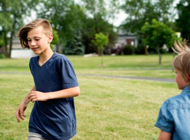 istock Young boys running and playing in suburb park. 1002438080