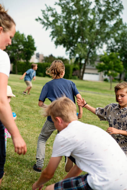 istock Group of kids running and playing in suburb park. 1002439046