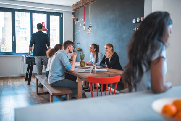 istock Web designers at cafeteria during break in office 1002439624