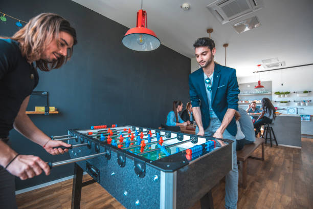 istock Male colleagues playing foosball in office 1002439688