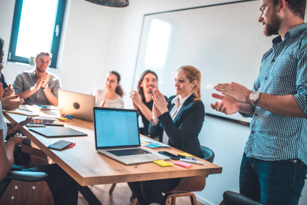 istock Business professionals applauding in board room 1002439748