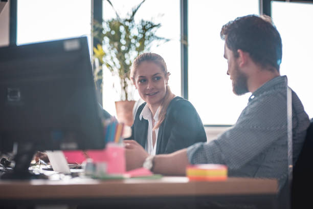istock Colleagues discussing at desk in office 1002439926