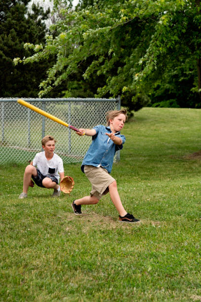 istock Brothers playing baseball in suburb park. 1002445634