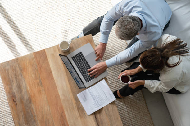 istock Successful couple at home working online on a laptop computer 1002488756