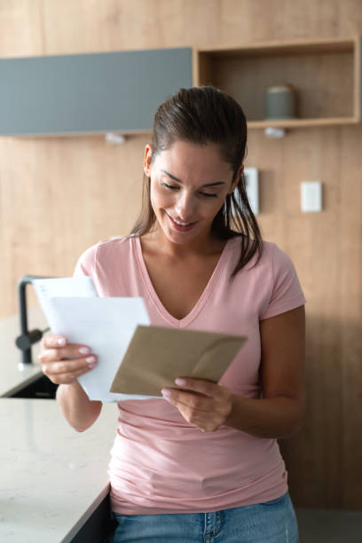 istock Beautiful woman at home checking her mail 1002488784