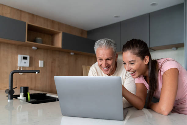 istock Happy couple watching videos on a laptop computer at home 1002488822