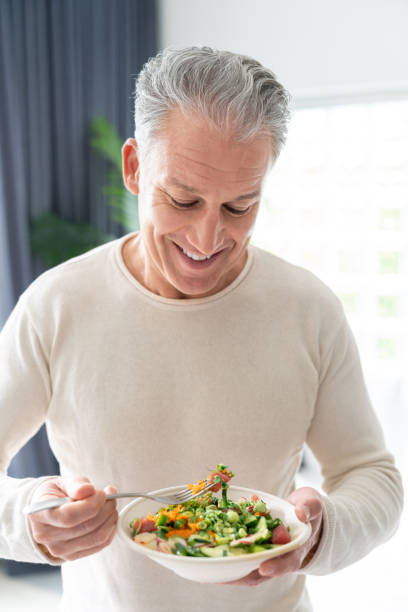 istock Healthy man at home eating a salad 1002488834