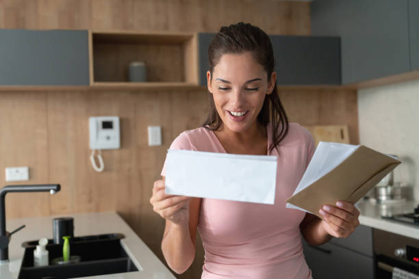istock Excited woman at home checking her mail 1002488888