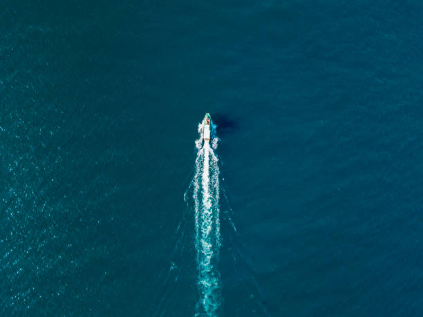 vue de dessus du bateau de voyage rapide va tout droit vers l’avant dans la prise de vue aérienne de mer - cruise speed photos et images de collection