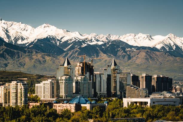 paisaje de la ciudad sobre un fondo de montañas nevadas del shan de tian en almaty kazajstán - almaty fotografías e imágenes de stock