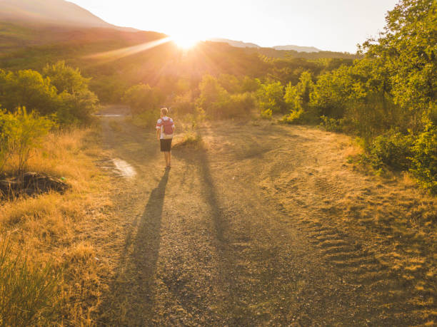 istock young man doing sport activity on a sunset summer running on the mountain dirt road 1002496710