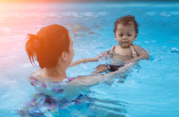 istock Mother And Son Swimming In Pool 1002501216