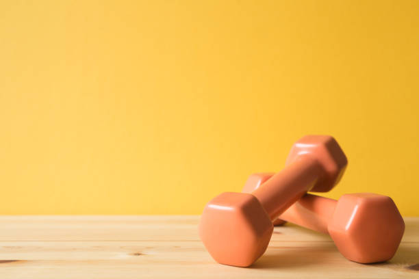 istock Fitness equipment dumbbells on wooden table (healthy lifestyle sport object) 1002508846