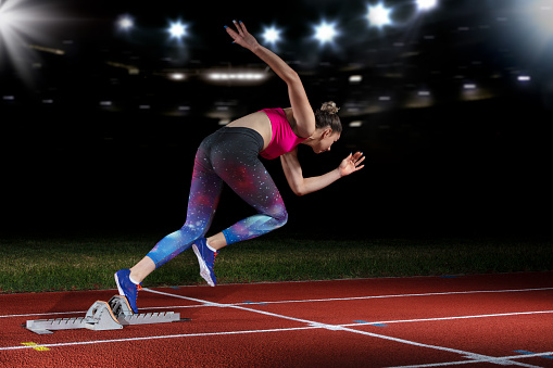 Woman Sprinter Leaving Starting Blocks On The Athletic Track Exploding ...