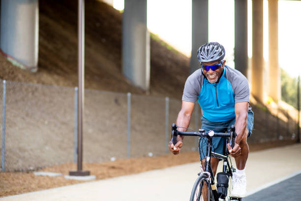 istock Senior Black Man Riding Bike on Trail 1002512128