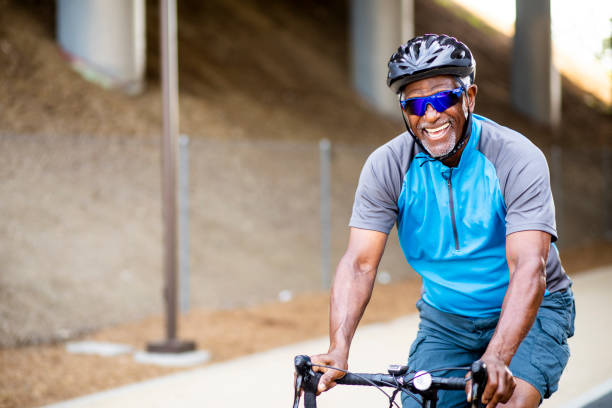 istock Senior Black Man Riding Bike on Trail 1002512154