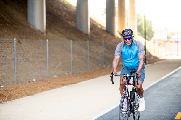istock Senior Black Man Riding Bike on Trail 1002512172