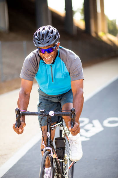 istock Senior Black Man Riding Bike on Trail 1002514400