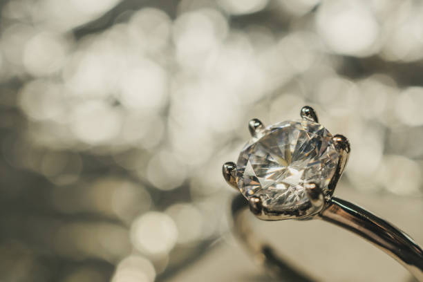 istock luxury engagement Diamond ring with abstract bokeh light background 1002517964
