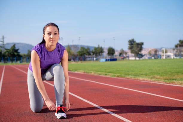 istock Young woman runner tying shoelaces. Exercise concept. 1002526086