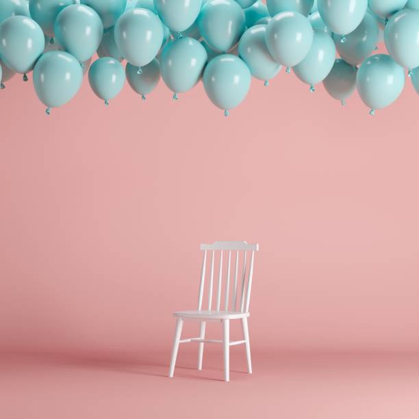 istock White chair with floating blue balloons in pink background room studio. minimal idea creative concept. 1002544696