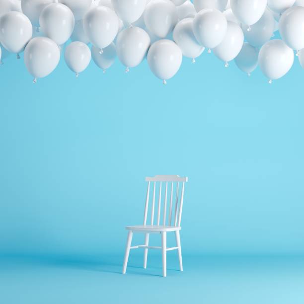 istock White chair with floating white balloons in blue background room studio. minimal idea creative concept. 1002544714