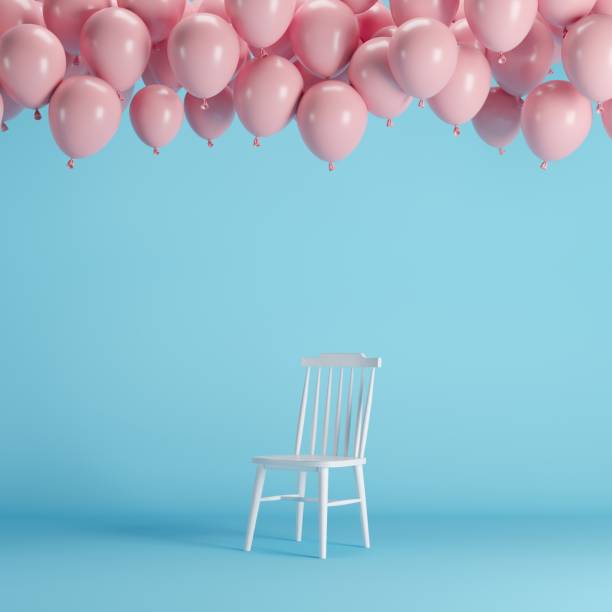 istock White chair with floating pink balloons in blue background room studio. minimal idea creative concept. 1002544748