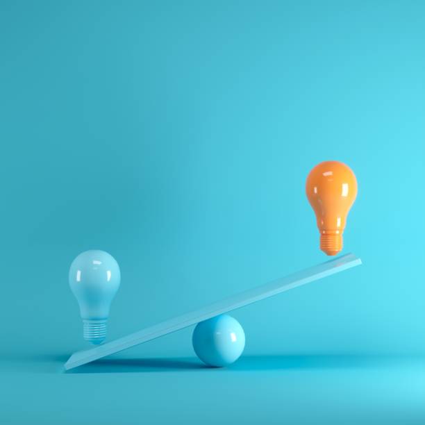 istock Outstanding Orange light bulb floating on blue seesaw on blue background, minimal idea concept. 1002544968