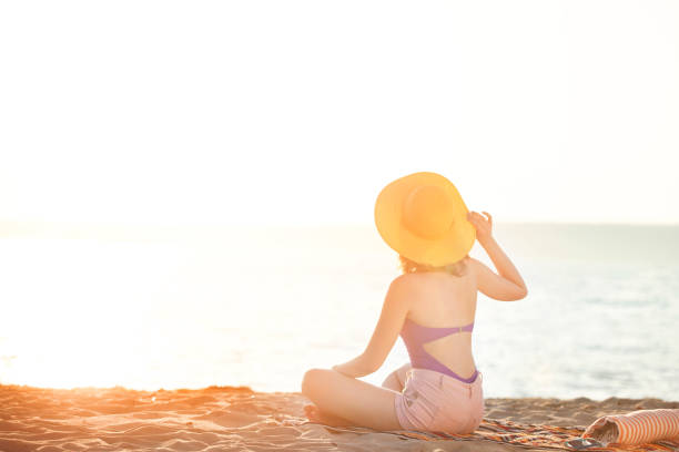 istock Young Woman Relaxing and Sunbathing at Beach 1002554182