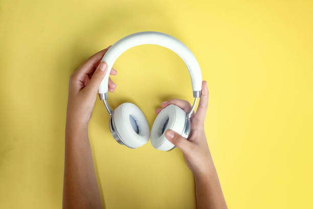 istock Female hands holding headphones. 1002567296