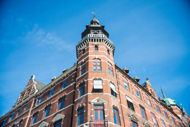 istock low angle view of building against bright blue sky in Copenhagen, Denmark 1002592432