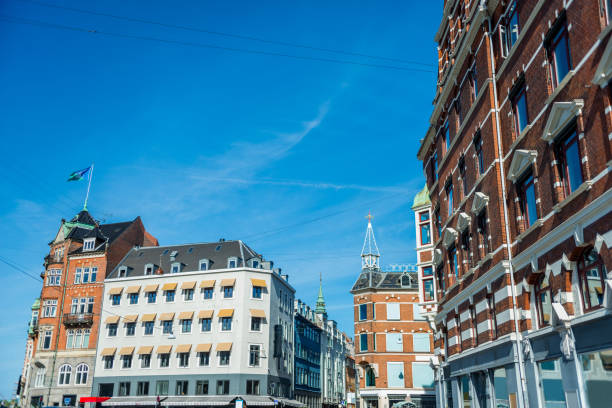 cityscape with buildings under bright blue sky in Copenhagen, Denmark
