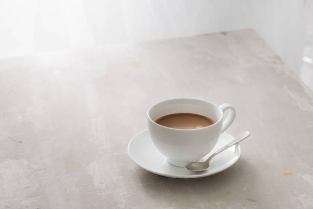 istock White china cup of tea with milk on a plain background 1002595494