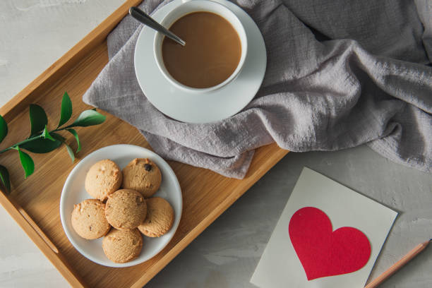 istock Tea with cookies in white cup plate with postcard 1002595770