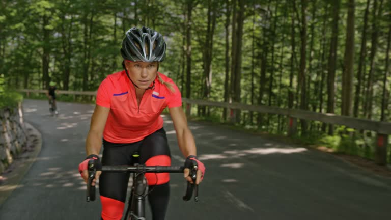 Female road cyclist speeding up the mountain road leaving another cyclist behind