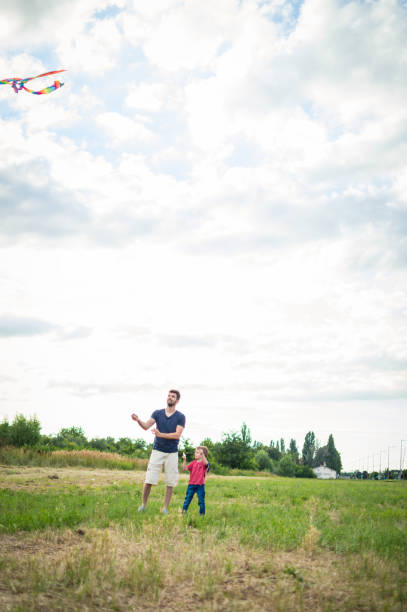 istock Little boy flying a kite with his father 1002611730